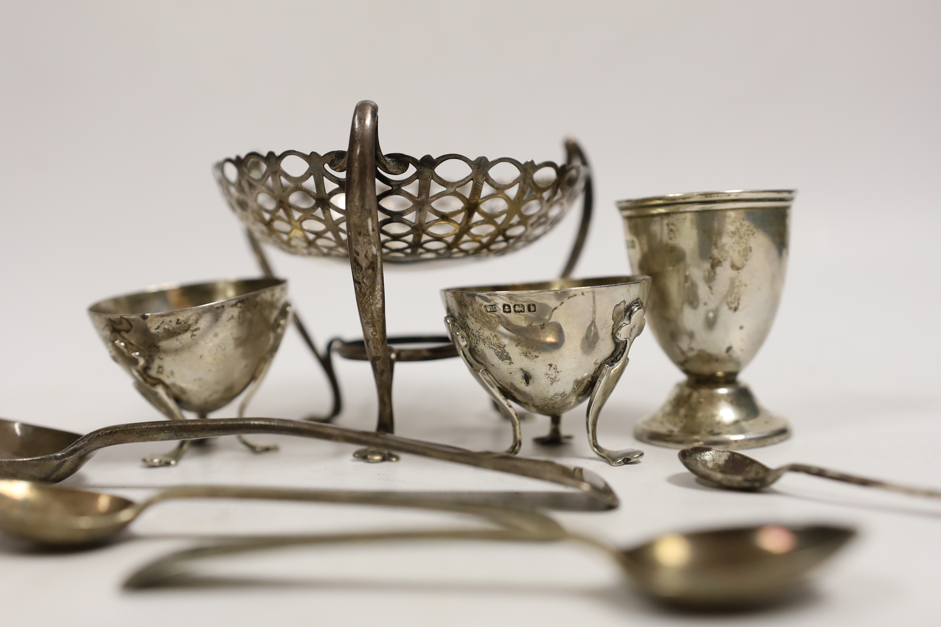 An Edwardian pieced silver bonbon dish on raised tripod supports, Birmingham, 1906, height 78mm, two small silver salts, a silver egg cup and four silver spoons, 7.7oz.